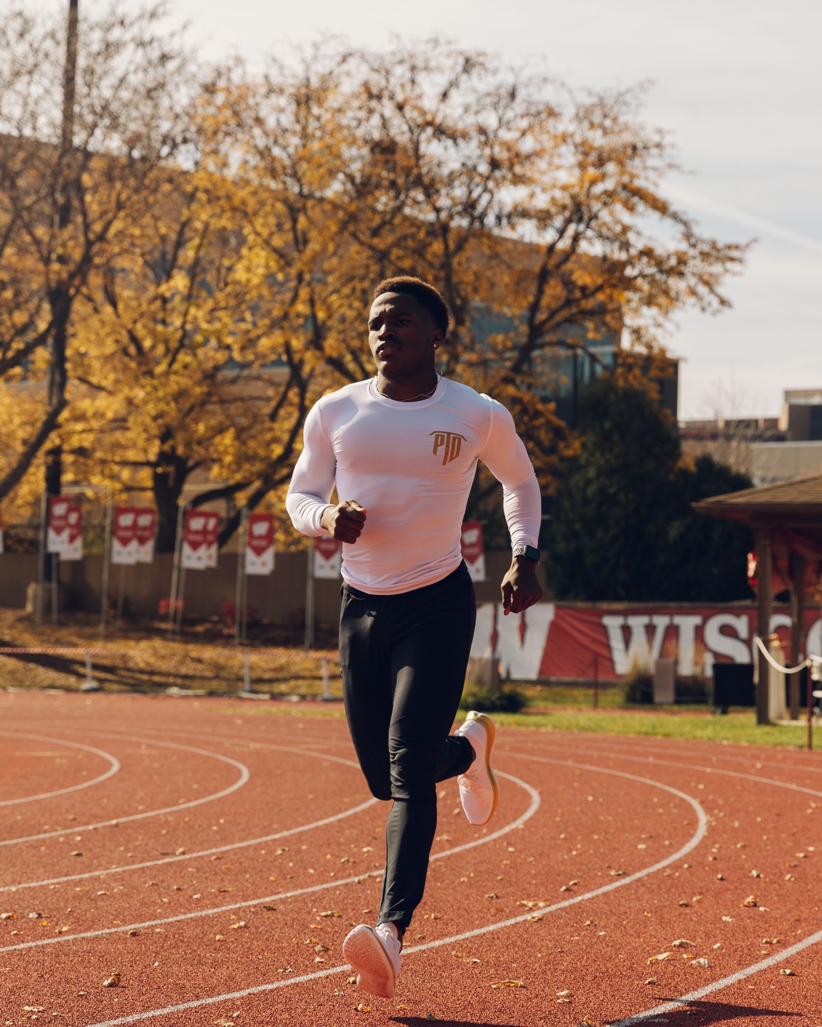 Lawrence L.O. Johnson running a curve on the Wisconsin track in autumn