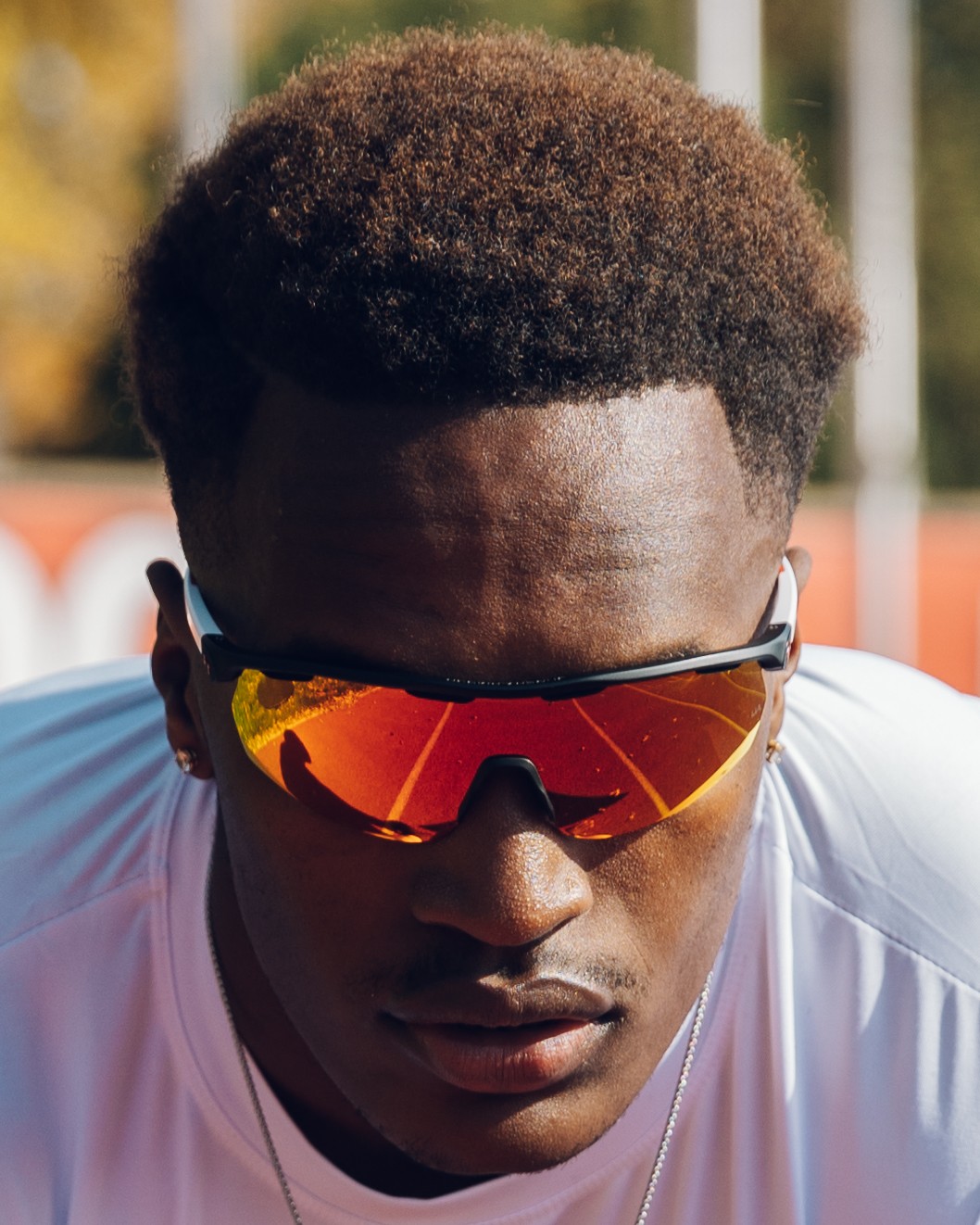 Close-up of Lawrence with the track reflected in his sunglasses